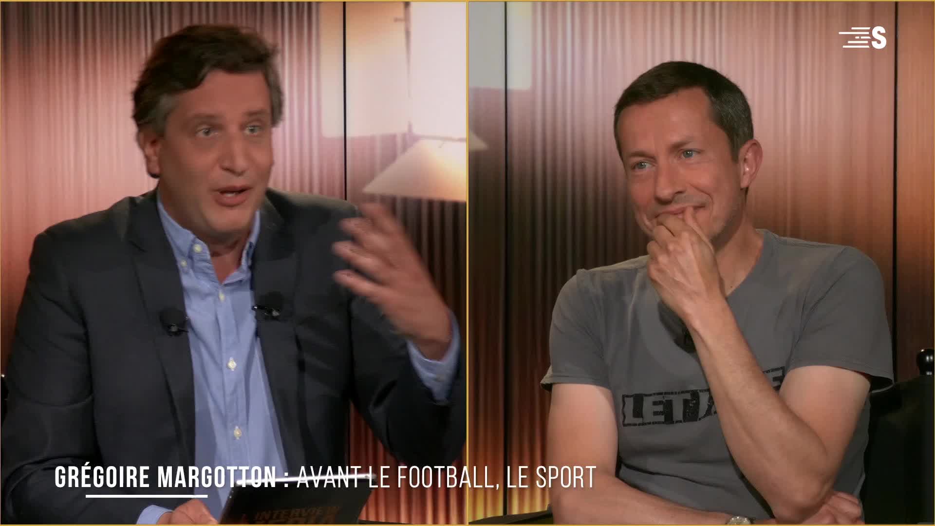 Grégoire Margotton, on Sport en France, gestures animatedly while speaking. The other man, in a grey t-shirt, listens with his hand to his chin, a slight smile playing on his lips.
