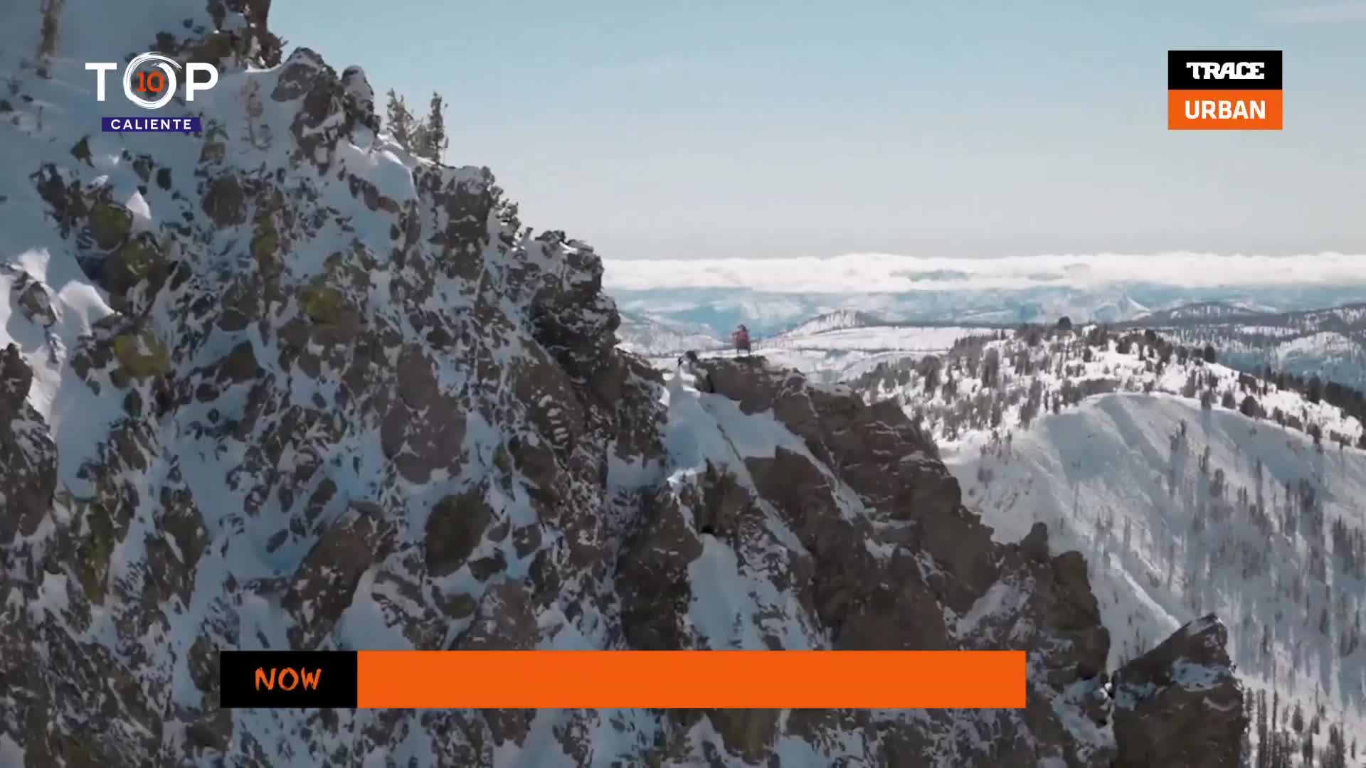 A person stands on a snowy mountain peak, silhouetted against the bright sky. The scene is broadcast on Trace Urban, a French music channel.
