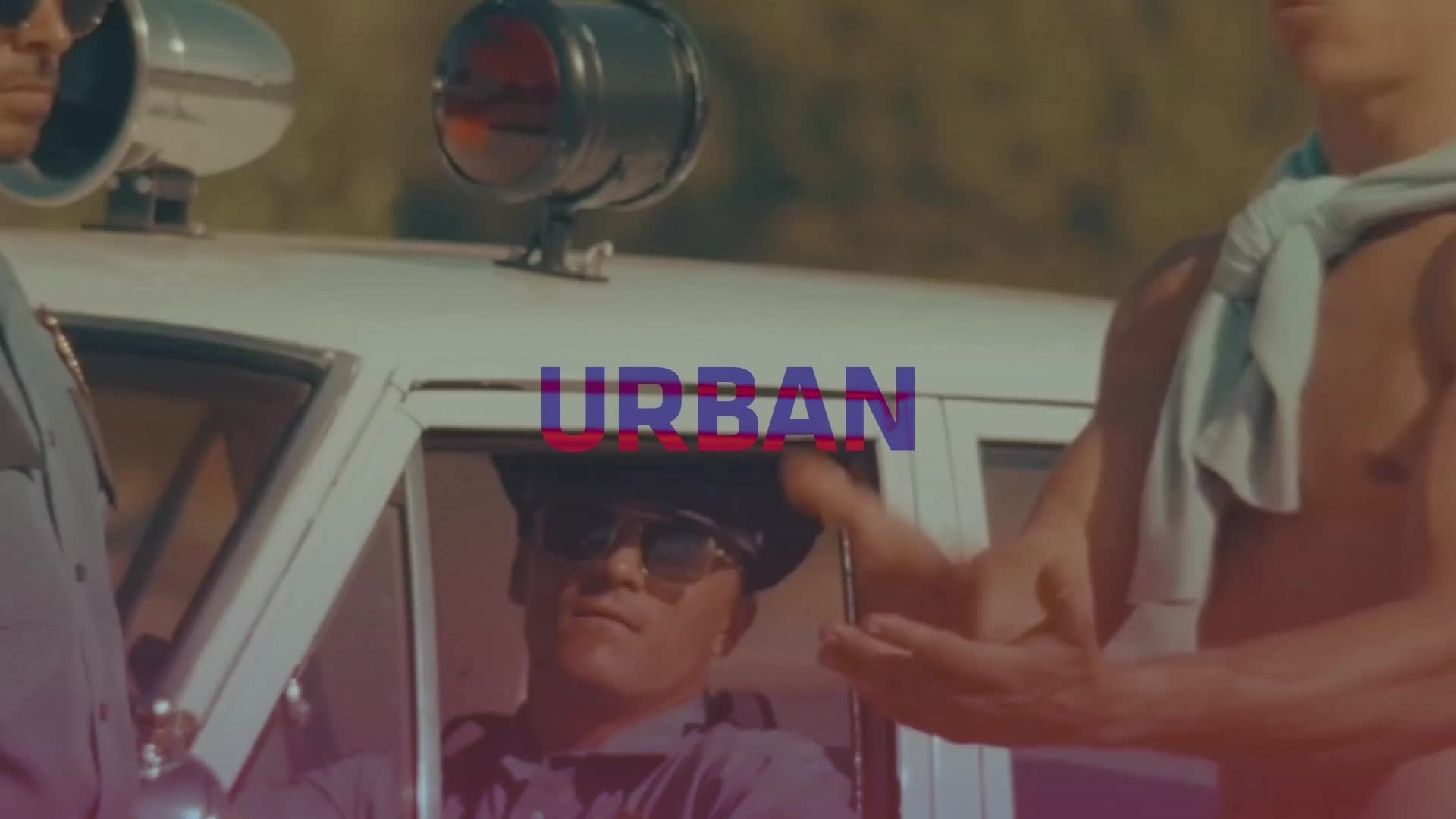 A police officer in sunglasses sits in his car, while a shirtless man gestures towards him. The word "URBAN" is overlaid in the center of the scene, suggesting a music video or promotional image.
