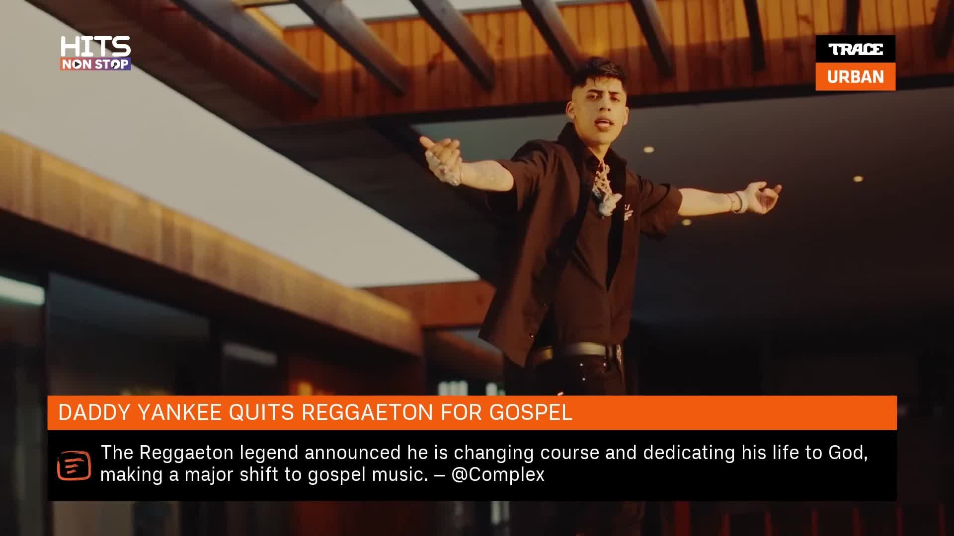 A man in a black shirt stands with arms outstretched, a large chain around his neck. The Trace Urban logo is in the corner, and the news banner announces Daddy Yankee's change of direction.
