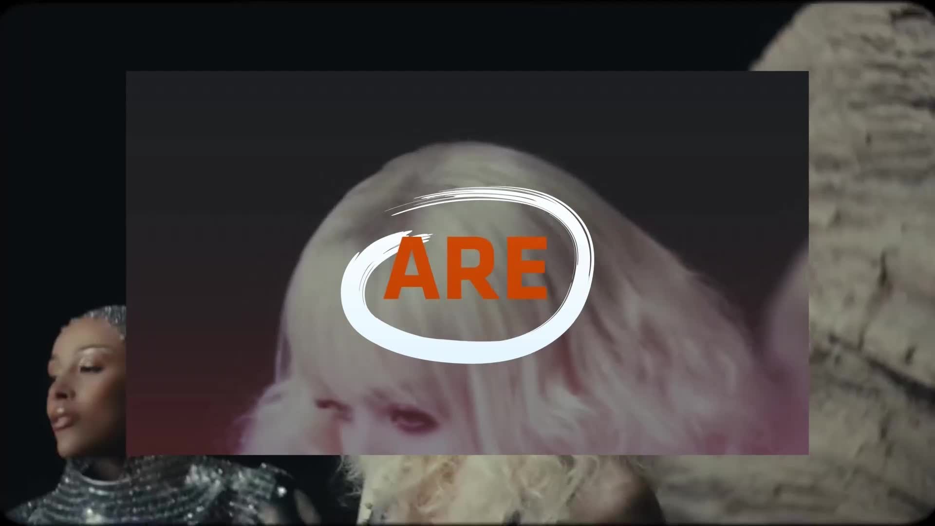 A woman with silver-dusted hair looks to the side, her face illuminated by a soft glow. Another woman, her blonde hair a pale halo, is partially visible behind a white circle containing the orange letters "ARE."