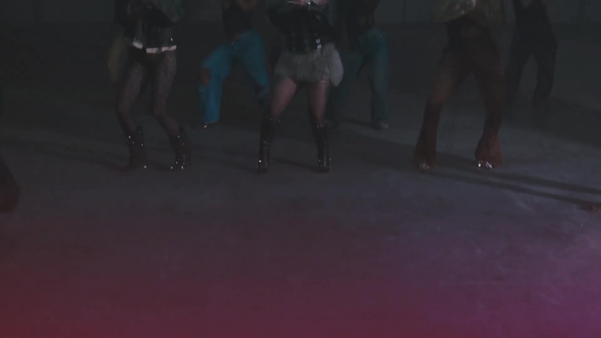 Several dancers in glittery outfits and tall boots move in unison. Their feet, clad in roller skates, glide across the floor. Several dancers in glittery outfits and tall boots move in unison. Their feet, clad in roller skates, glide across the floor.