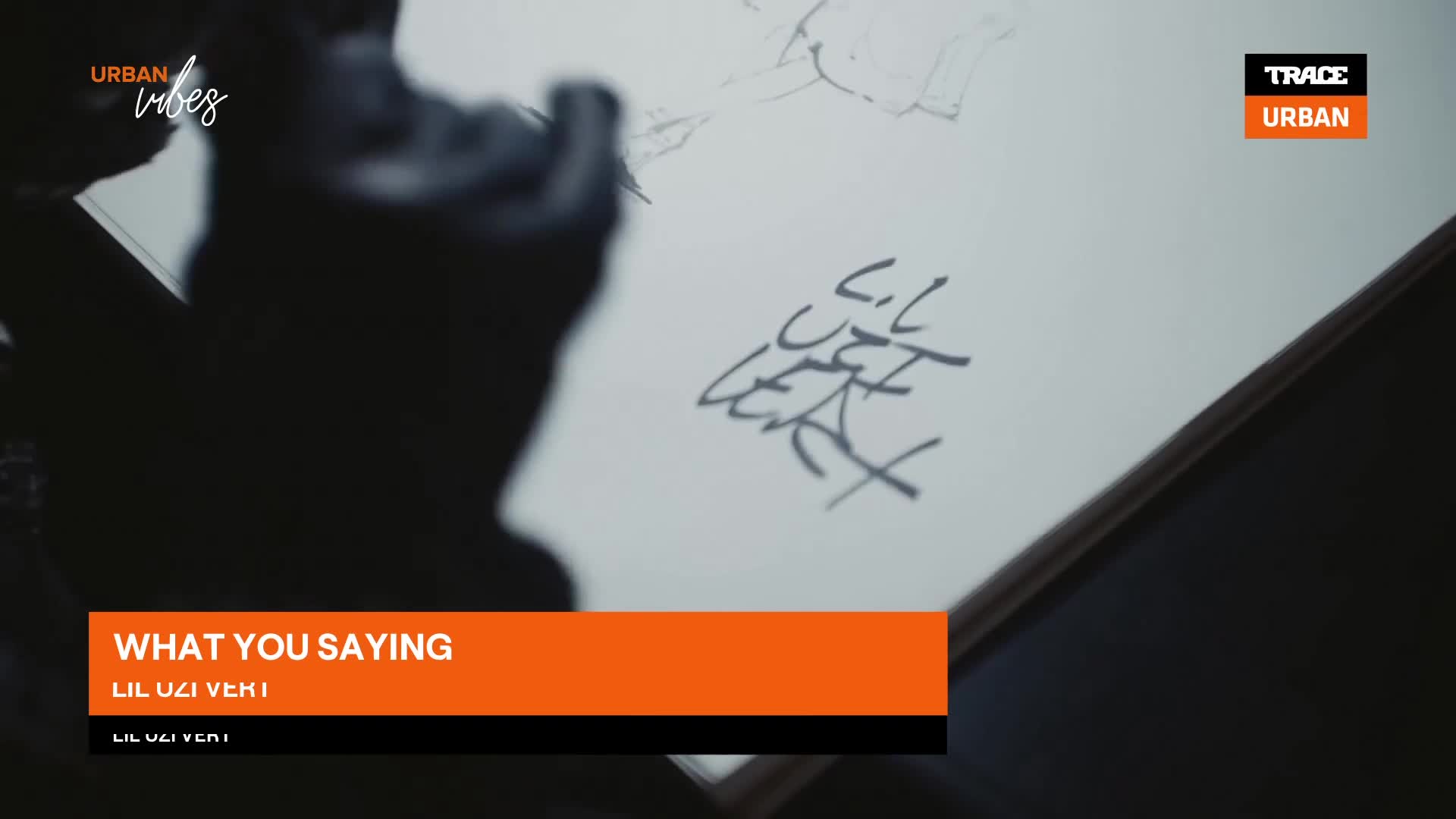 A hand sketches a signature onto a white page. The Trace Urban logo is visible in the corner. A hand sketches a signature onto a white page. The Trace Urban logo is visible in the corner.