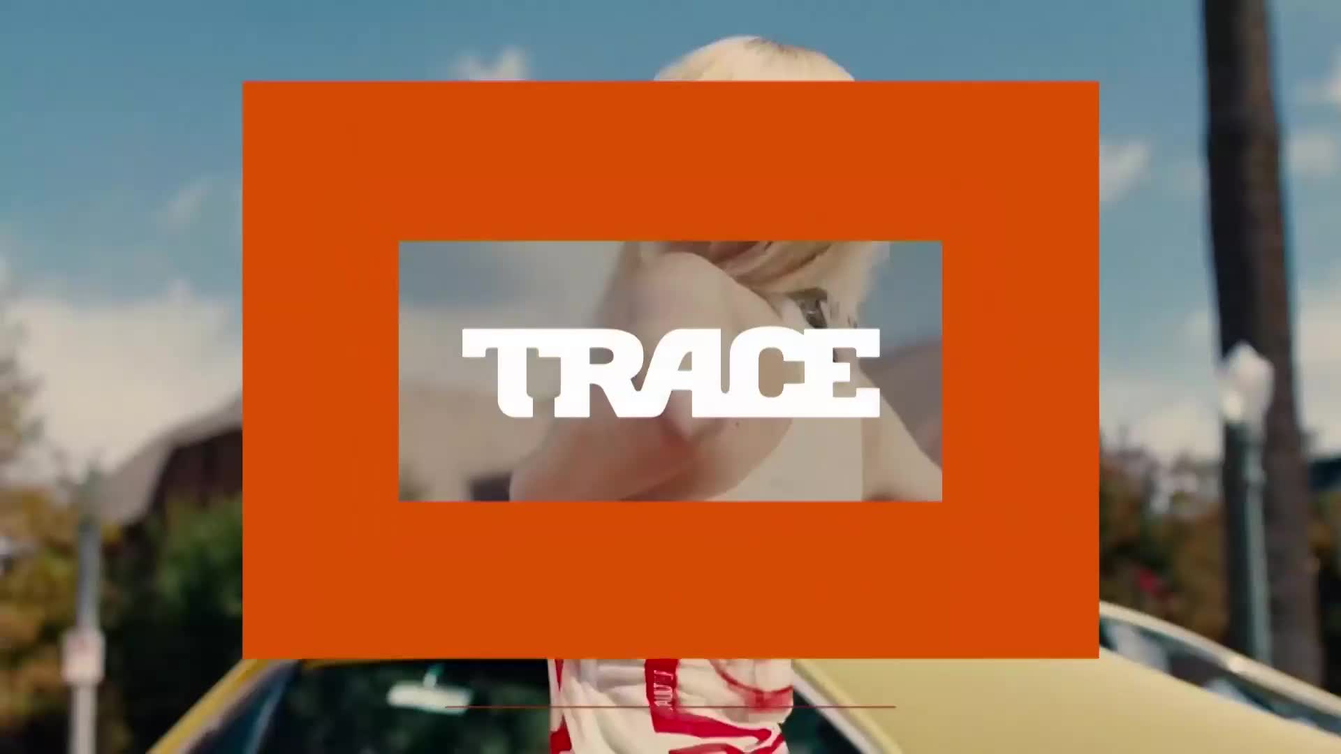 A bright orange frame cuts across the scene, with the word "TRACE" in bold white letters inside a smaller rectangle. A yellow car is parked nearby, and a person with blonde hair is visible behind the frame. A bright orange frame cuts across the scene, with the word "TRACE" in bold white letters inside a smaller rectangle. A yellow car is parked nearby, and a person with blonde hair is visible behind the frame.