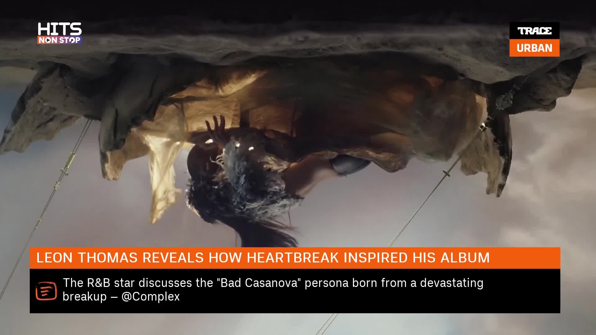 A figure with dark, wild hair and glowing eyes is suspended from what looks like a rocky overhang. The scene is lit with a warm, diffused light, and the overall impression is one of dramatic intensity. A figure with dark, wild hair and glowing eyes is suspended from what looks like a rocky overhang. The scene is lit with a warm, diffused light, and the overall impression is one of dramatic intensity.