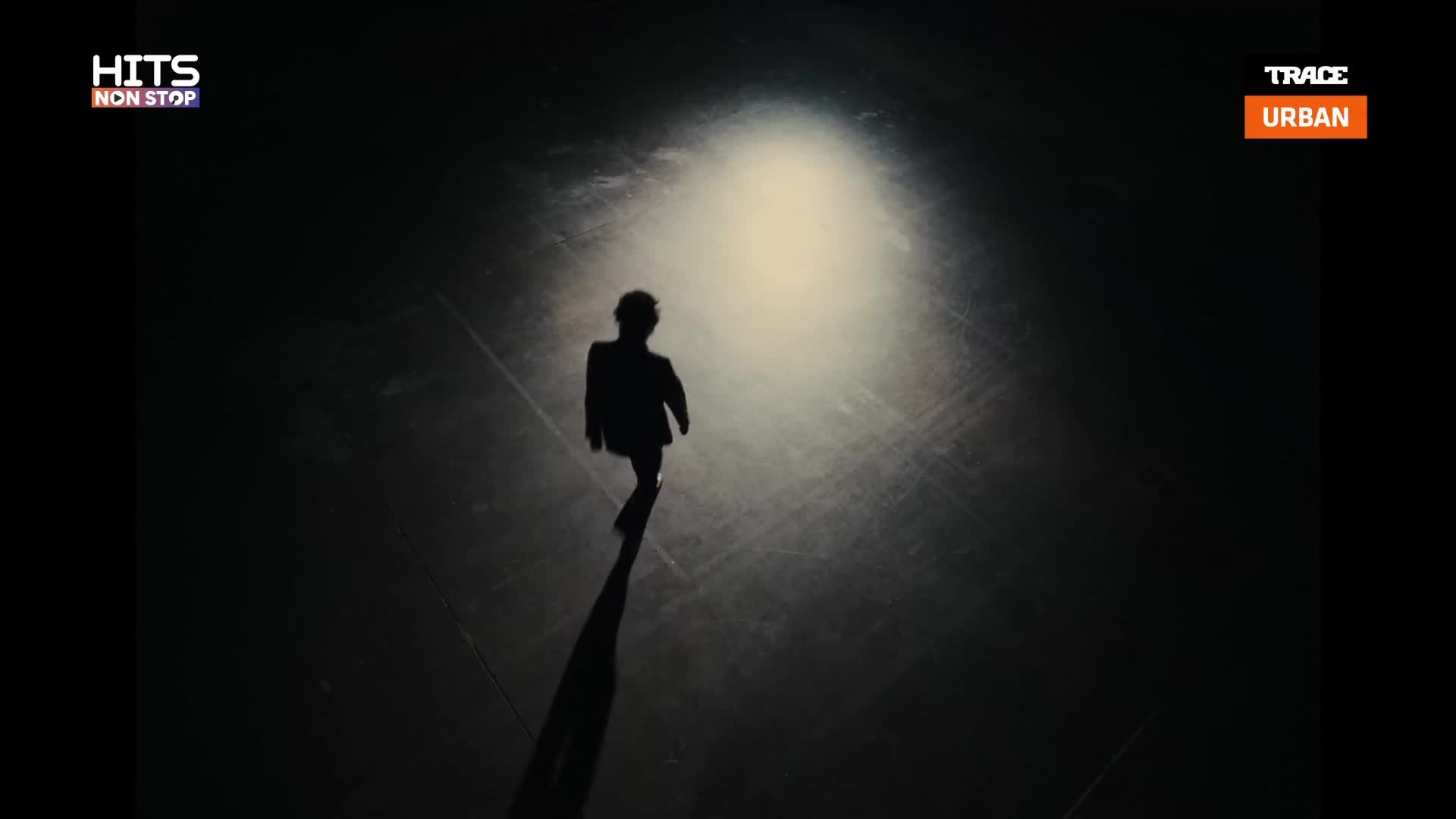 A lone figure in a suit walks away from a bright light, their shadow stretching long behind them on the dark, textured ground. This is the kind of scene you'd catch on Trace Urban, playing a track that feels like a late-night stroll through Paris. A lone figure in a suit walks away from a bright light, their shadow stretching long behind them on the dark, textured ground. This is the kind of scene you'd catch on Trace Urban, playing a track that feels like a late-night stroll through Paris.
