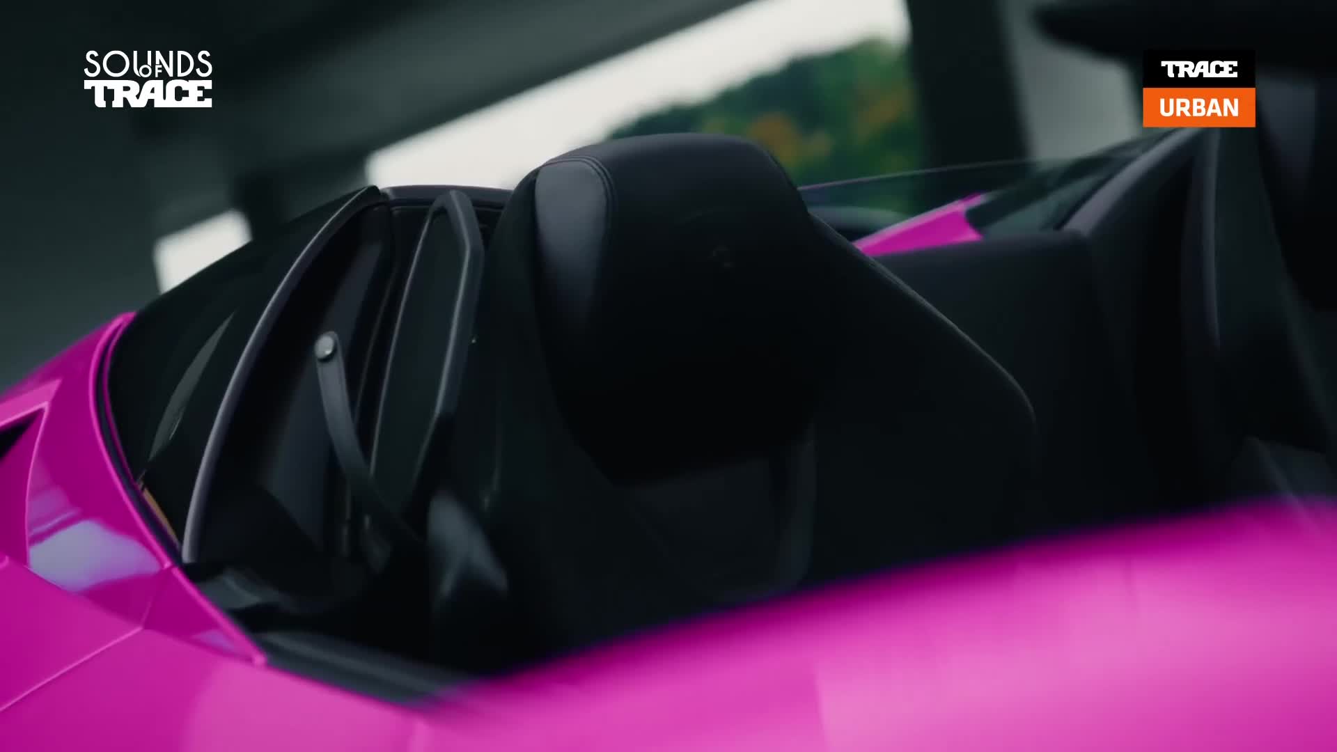 The vibrant pink sports car is parked, its sleek lines catching the light. The Trace Urban logo is visible, hinting at a stylish urban vibe. The vibrant pink sports car is parked, its sleek lines catching the light. The Trace Urban logo is visible, hinting at a stylish urban vibe.