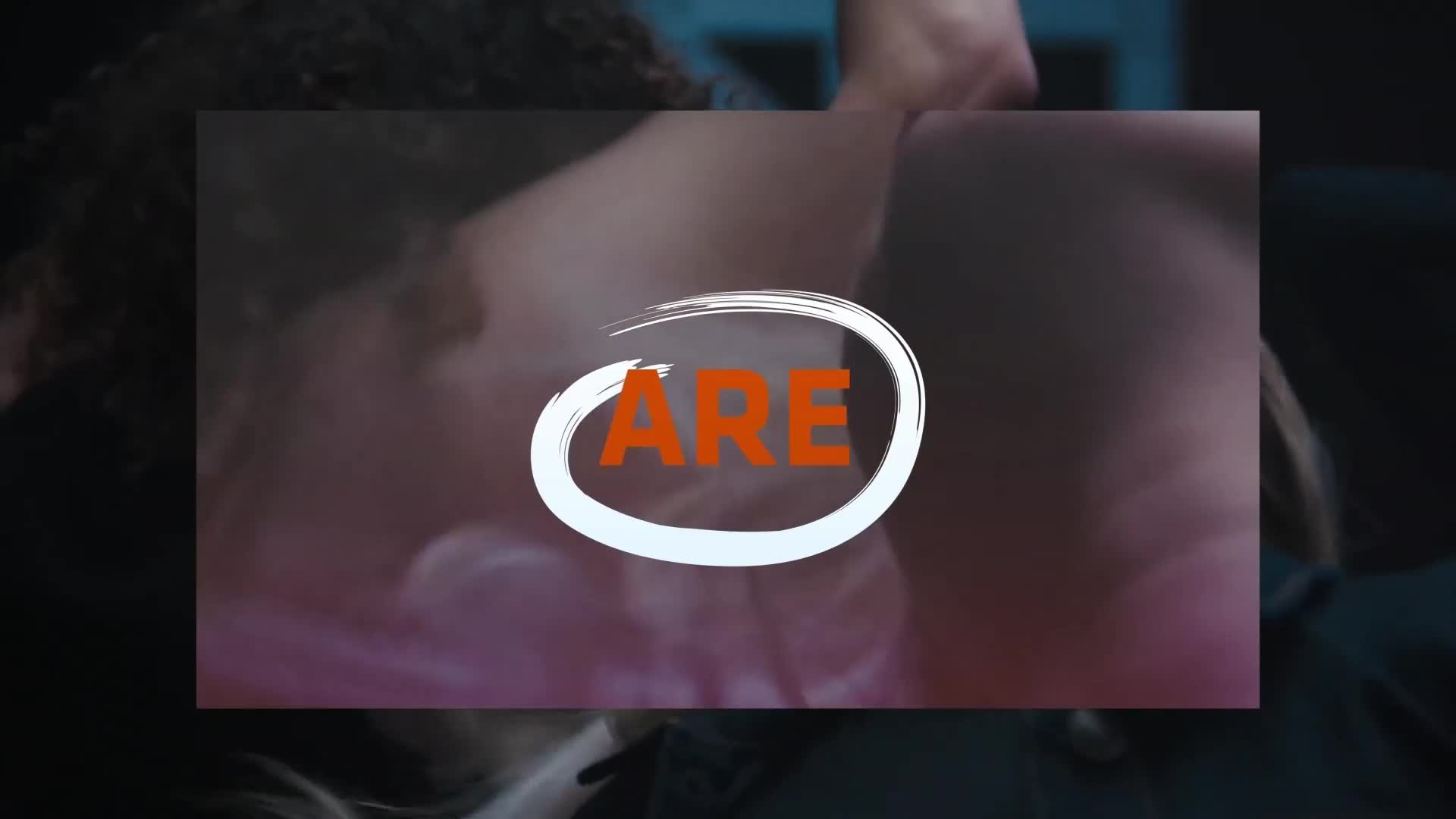 A white circle with orange letters spelling "ARE" hovers over a close-up of two people. The background is dark, with hints of pink and blue light. A white circle with orange letters spelling "ARE" hovers over a close-up of two people. The background is dark, with hints of pink and blue light.