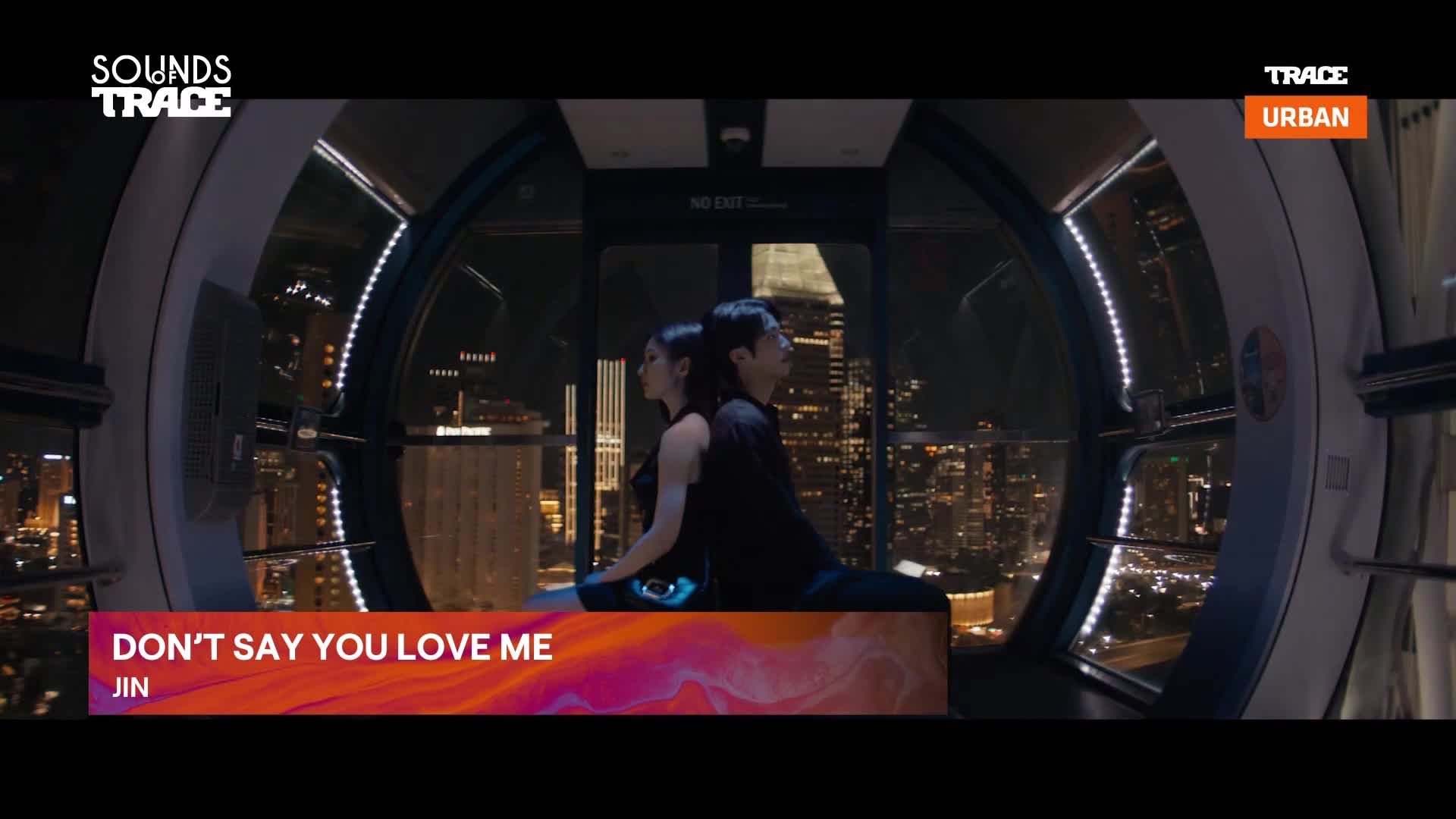 A couple sits back-to-back in a gondola, the city lights of Paris twinkling below. The Trace Urban logo flashes on screen, announcing "Don't Say You Love Me" by Jin.
