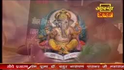 A golden statue of Ganesha sits centered on a screen, framed by a teal background. The Aastha Bhajan logo is visible in the upper right corner, and the bottom banner suggests this is a religious broadcast from India.
