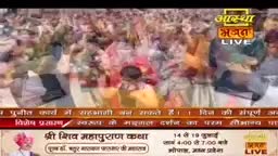 A large crowd, many wearing colorful clothing, is gathered closely together. The Aastha Bhajan logo indicates this is a live broadcast from India, likely of a religious event.
