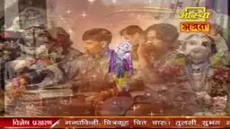 The Aastha Bhajan logo sits above a group of people, likely in India, gathered together. They appear to be participating in a religious ceremony, with a statue and other decorations visible.
