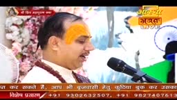 A man with a saffron mark on his forehead speaks into a microphone, likely during a broadcast on Aastha Bhajan. Behind him, the Indian flag is visible, and text at the bottom promotes booking accommodations.
