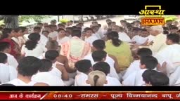 A large group of people, many in white, are gathered closely together.  The Aastha Bhajan logo sits above the crowd, suggesting a religious gathering in India.
