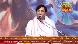 A man in a white kurta speaks into a microphone, his voice amplified for the Aastha Bhajan broadcast. Behind him, a painted backdrop shows a religious image, and a banner at the bottom displays information in Hindi.
A man in a white kurta speaks into a microphone, his voice amplified for the Aastha Bhajan broadcast. Behind him, a painted backdrop shows a religious image, and a banner at the bottom displays information in Hindi.