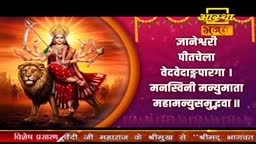 A goddess with multiple arms rides a powerful lion, bathed in golden light.  Text in Hindi scrolls across a vibrant purple background, likely from an Aastha Bhajan broadcast.