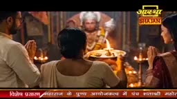 A family offers prayers before a deity, their hands pressed together in reverence. The warm glow of oil lamps illuminates the sacred space, creating an atmosphere of devotion.