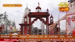 A grand, red gateway stands before a white temple spire, its intricate carvings hinting at a vibrant Indian celebration. Above, a sign for "Aastha Bhajan" glows, promising spiritual melodies.