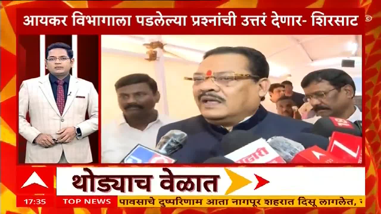 A man in glasses and a dark suit is speaking into a cluster of microphones, surrounded by other men. The ABP Majha logo sits at the bottom of the screen, with a news ticker running below it.
