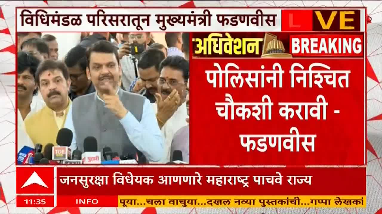 Devendra Fadnavis, speaking into a cluster of microphones, gestures with his right hand.  The ABP Majha screen behind him displays a breaking news headline in Marathi.
