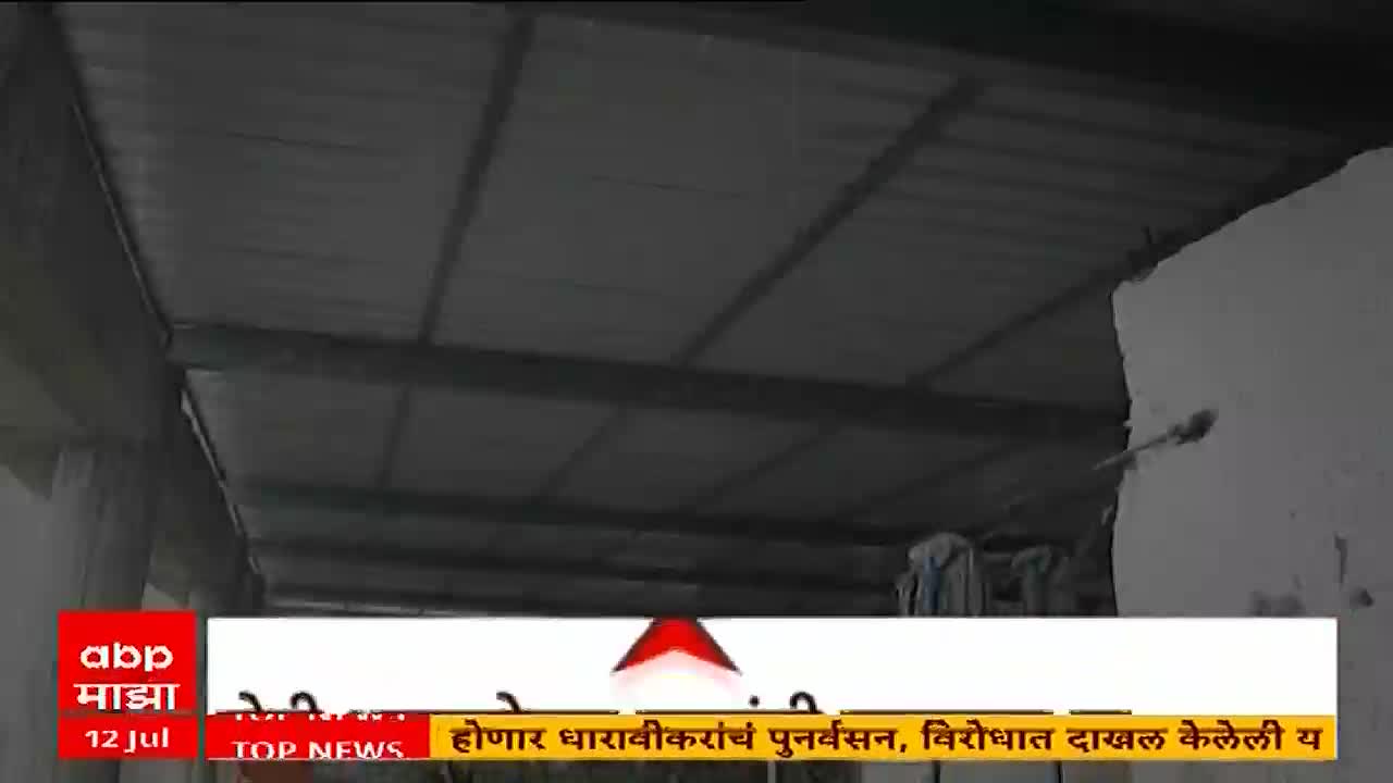 A news segment from ABP Majha is running, with a headline about Dharavi's redevelopment. The camera angle looks up at a corrugated metal roof and a white wall.

