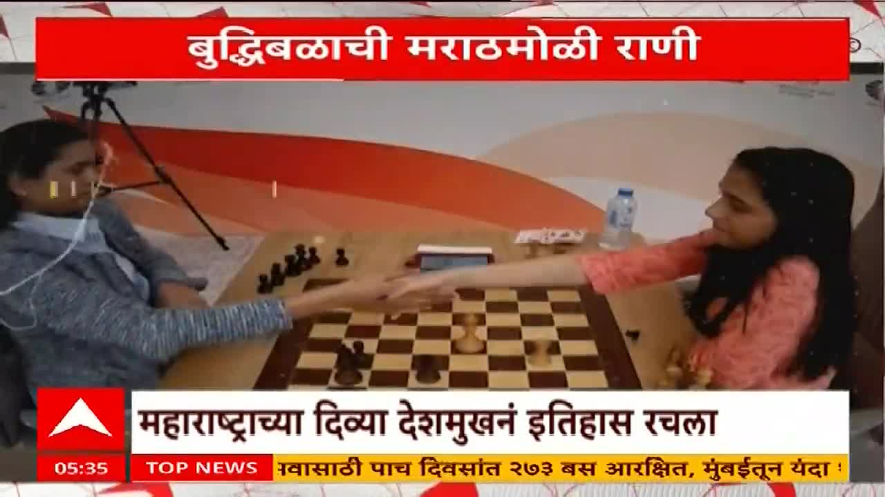 Two women, seated across a chessboard, reach across the board to shake hands. The ABP Majha news segment highlights the achievement of Divya Deshmukh from Maharashtra.
