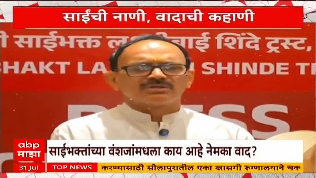 A man in glasses, wearing a white shirt, speaks directly into the camera. Behind him, a red banner with Marathi text is visible, likely from ABP Majha, a news channel in India.
