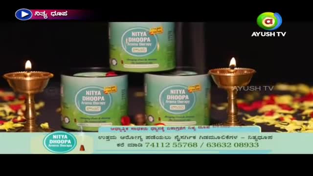On a table, three cylindrical containers of "Nitya Dhoopa Aroma Therapy" are stacked, with two small lamps burning brightly. The Ayush TV logo is visible in the corner, and text in Kannada runs along the bottom.
