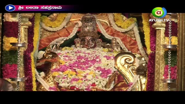 A golden idol, adorned with flowers, sits centered in a shrine. The scene is being broadcast on Ayush TV, with a title card in the upper left corner.
