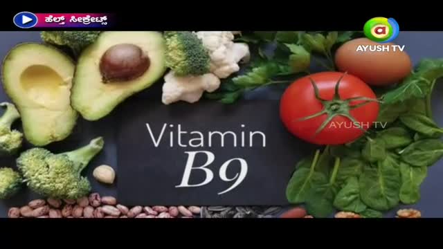 Fresh produce like avocado, broccoli, and a tomato are arranged around the words "Vitamin B9" on a dark surface. The Ayush TV logo sits in the corner, suggesting this is a segment about healthy eating.
