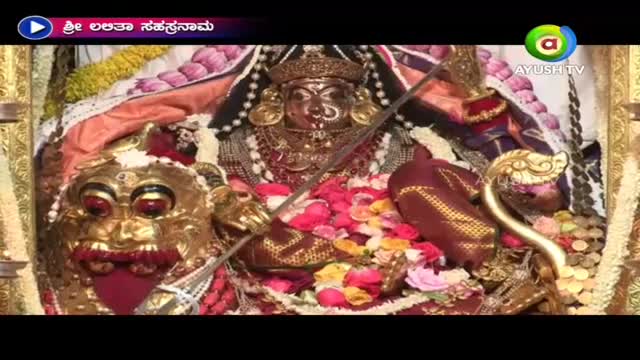 A golden statue, adorned with jewels, is the central focus, framed by a decorative border. The Ayush TV logo marks the broadcast of a devotional scene, likely from India.
