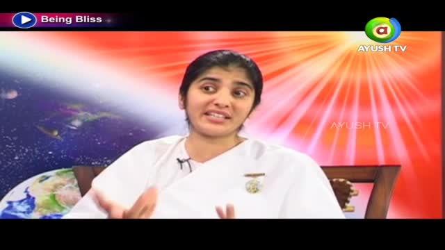 A woman in a white robe is speaking, gesturing with her hands. The Ayush TV logo is visible in the corner, and the background is a bright, abstract design.
