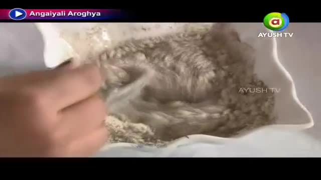 A hand is stirring a light-colored, grainy substance inside a white container. The scene is from Ayush TV, and the show is called Angaiyali Aroghya.
A hand is stirring a light-colored, grainy substance inside a white container. The scene is from Ayush TV, and the show is called Angaiyali Aroghya.