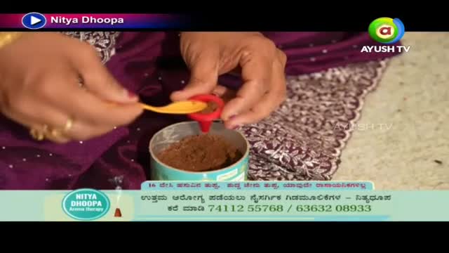A hand carefully pours a brown powder from a small yellow spoon into a red, circular holder. The scene is part of a segment on Ayush TV, focusing on Nitya Dhoopa, an aroma therapy.
A hand carefully pours a brown powder from a small yellow spoon into a red, circular holder. The scene is part of a segment on Ayush TV, focusing on Nitya Dhoopa, an aroma therapy.