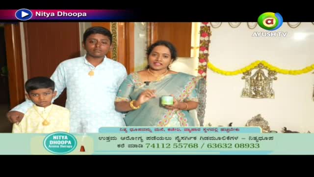 A woman in a sari holds a small container, gesturing with her other hand. Two young boys stand beside her, all three facing the camera on what looks like a set for Ayush TV.
A woman in a sari holds a small container, gesturing with her other hand. Two young boys stand beside her, all three facing the camera on what looks like a set for Ayush TV.