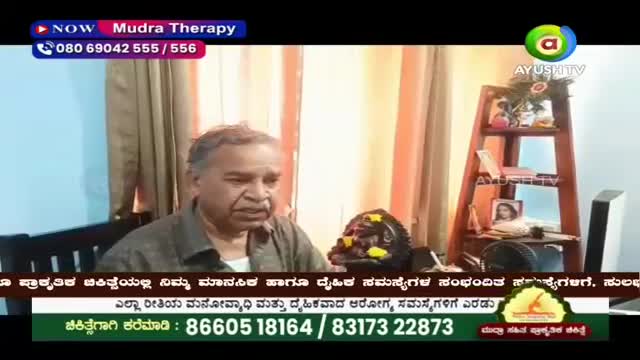 A man speaks on screen, a small, dark sculpture with yellow flowers sits beside him. The Ayush TV logo is visible in the corner.