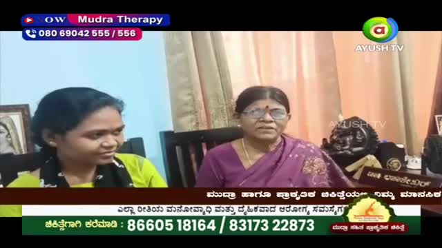 Two women sit in front of a camera, one in a bright yellow top and the other in a purple sari. A graphic overlay from Ayush TV displays contact information.