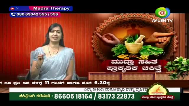 A woman in a light blue sari speaks, gesturing with her right hand. Behind her, Ayush TV displays graphics of hands, herbs, and a mortar and pestle.