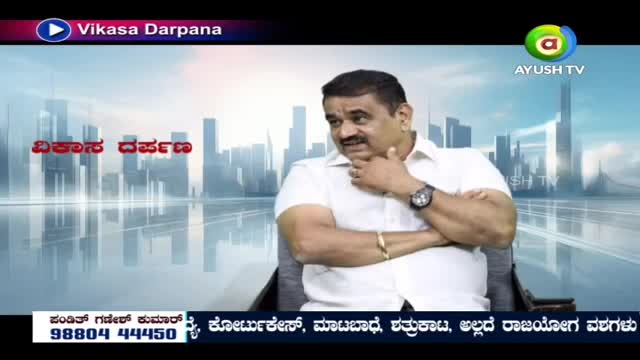 A man in a white shirt sits with his arms crossed, looking off to the side. The Ayush TV logo is visible in the upper right corner.