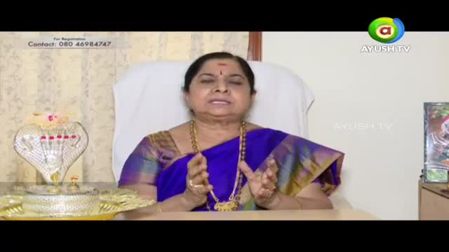 A woman in a blue sari speaks, her hands gesturing. Beside her, a silver cobra statue gleams on a decorative tray. The Ayush TV logo appears in the corner. A woman in a blue sari speaks, her hands gesturing. Beside her, a silver cobra statue gleams on a decorative tray. The Ayush TV logo appears in the corner.