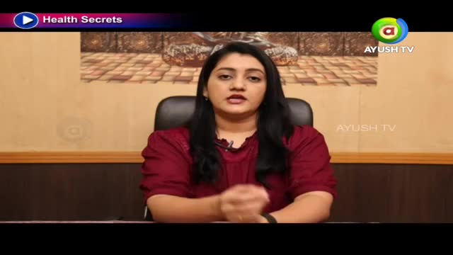 A woman in a maroon top speaks directly to the camera. The "Health Secrets" program logo appears in the upper left corner. A woman in a maroon top speaks directly to the camera. The "Health Secrets" program logo appears in the upper left corner.