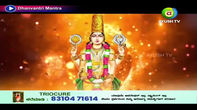 A divine figure, adorned in gold and vibrant silks, holds glowing discs in each hand. The screen displays "Dhanvantri Mantra" and the Ayush TV logo, hinting at a spiritual broadcast from India.