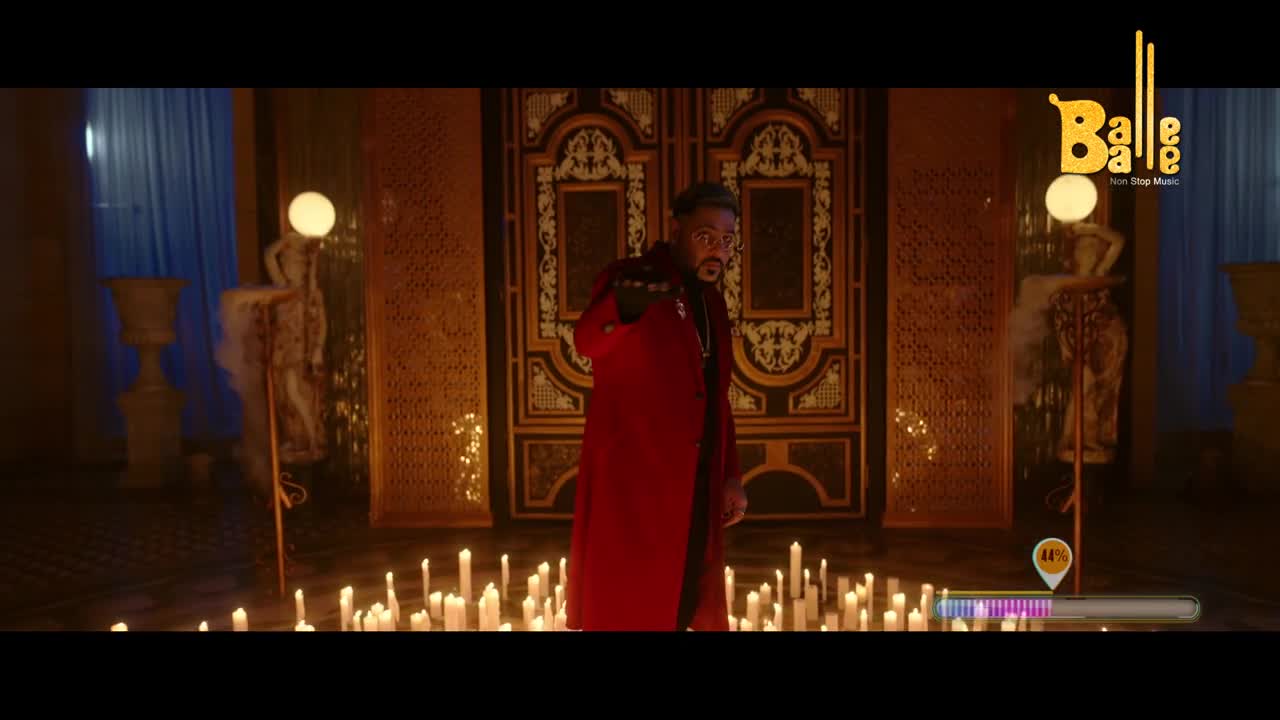 A man in a long red coat stands center, gesturing with his hand as the candles around him flicker. The Balle Balle logo is visible, and a song meter pulses below.
