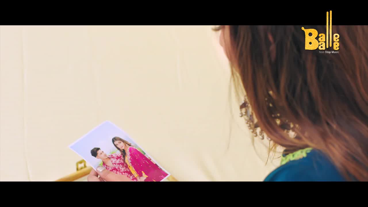 A woman, partially in frame, holds a photograph of two people in colorful Indian attire. The "Balle Balle" logo sits in the top right corner.
