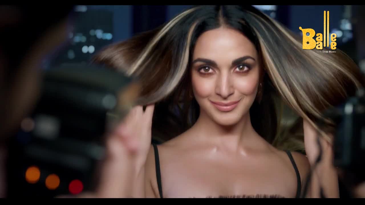 The woman, looking directly at the camera, gently lifts her hair, the highlights catching the light. The "Balle Balle" logo sits in the corner, promising music and a good time.
