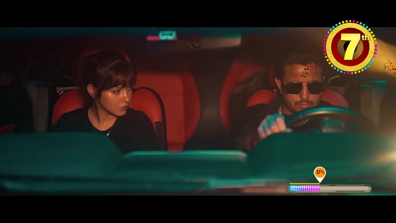 Inside a car, a woman with dark hair stares ahead, while the driver, wearing sunglasses, grips the steering wheel. A progress bar at the bottom of the screen indicates something is underway.
