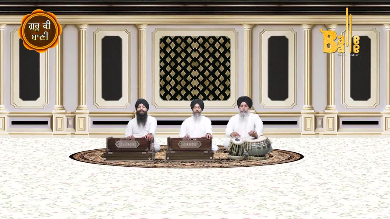 Three men in white robes sit on a patterned rug, playing instruments. The middle one pumps a harmonium, while the others play a tabla and another harmonium.
