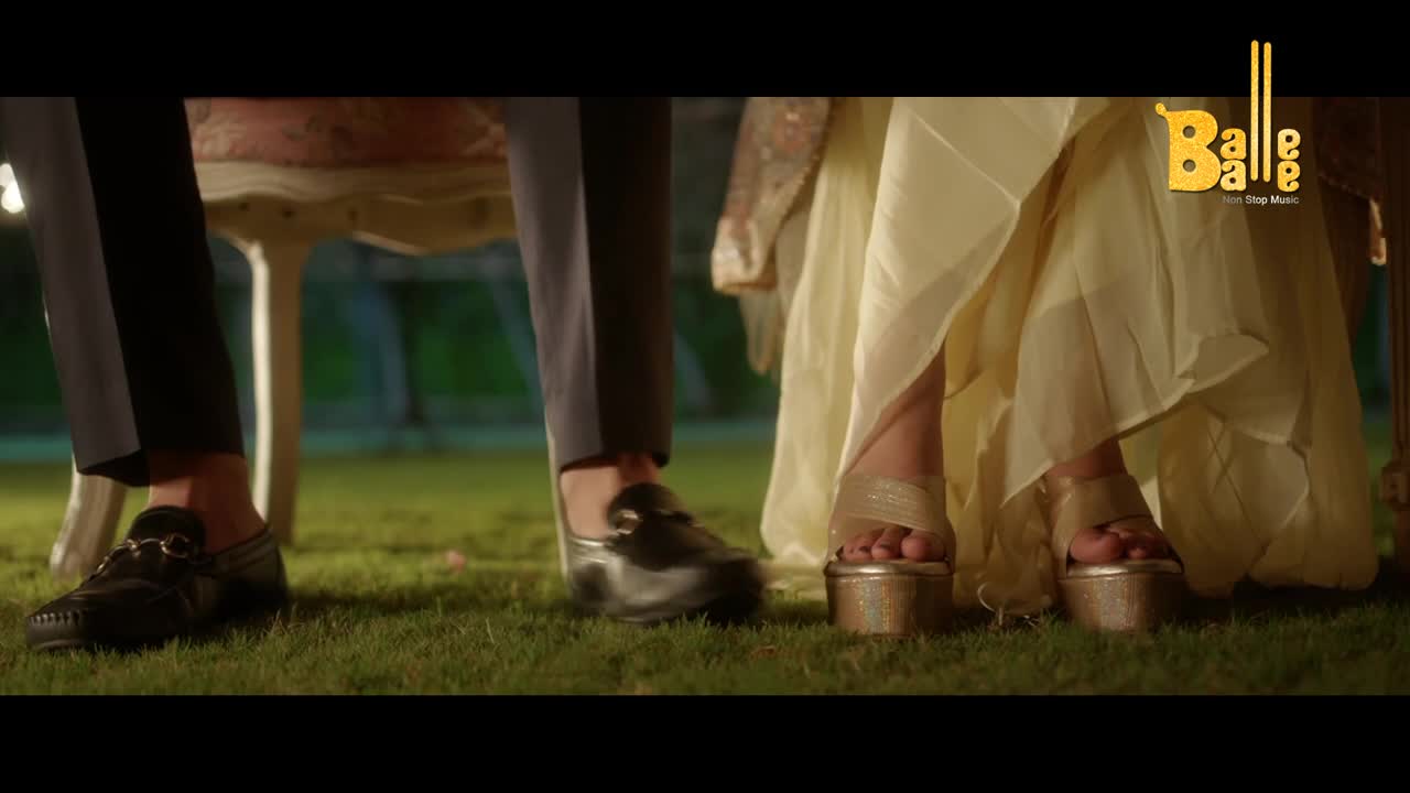 The man's black loafers sit still on the grass, while the woman's platform sandals are poised, ready to move. A flowing, pale yellow dress drapes around her feet, and the Balle Balle logo sits in the corner.
The man's black loafers sit still on the grass, while the woman's platform sandals are poised, ready to move. A flowing, pale yellow dress drapes around her feet, and the Balle Balle logo sits in the corner.