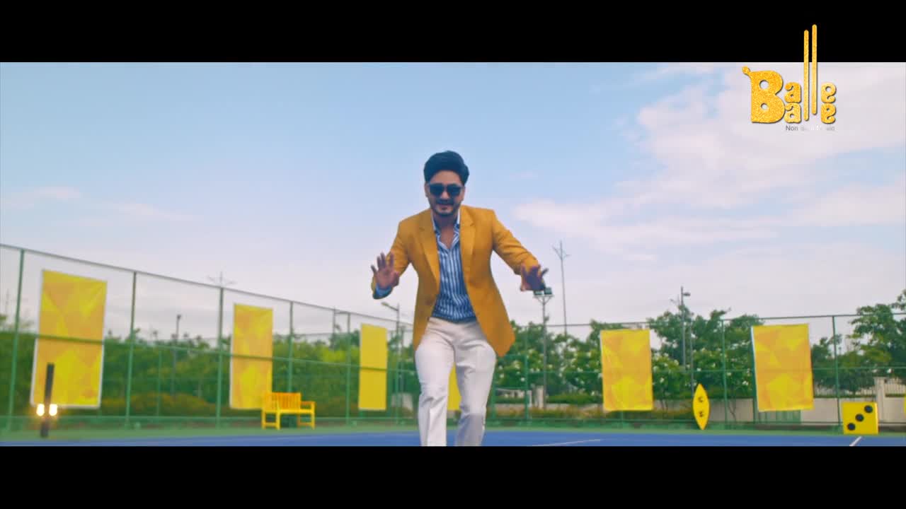 A man in a bright yellow blazer strides forward on a tennis court, arms outstretched, as if dancing. The Balle Balle logo floats in the corner, hinting at the music video vibe.
A man in a bright yellow blazer strides forward on a tennis court, arms outstretched, as if dancing. The Balle Balle logo floats in the corner, hinting at the music video vibe.