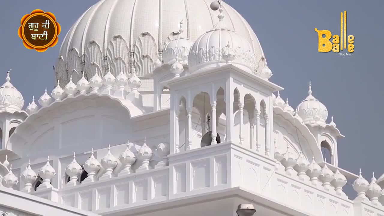 The white marble of the Gurdwara gleams in the sunlight, its domes and ornate details reaching towards the sky.  The "Balle Balle" logo floats above the building, a reminder of the music and celebration.
